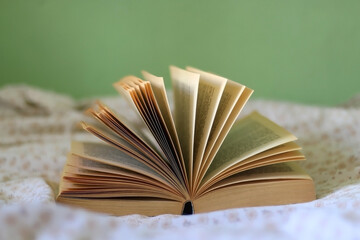 Open book on a bed. Selective focus.
