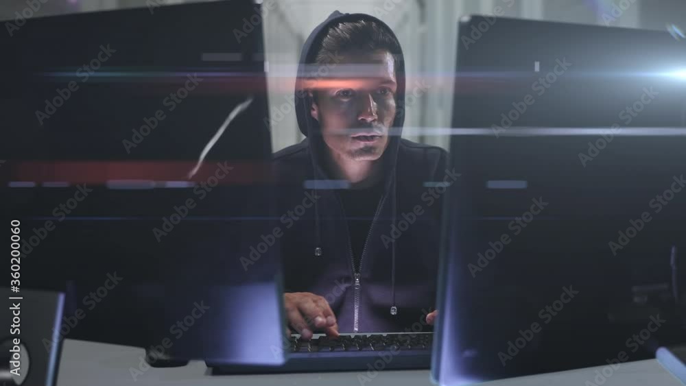 Poster Caucasian hooded hacker man with two computers