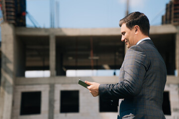 Stylish young man holds a digital tablet against the backdrop of the city background. The