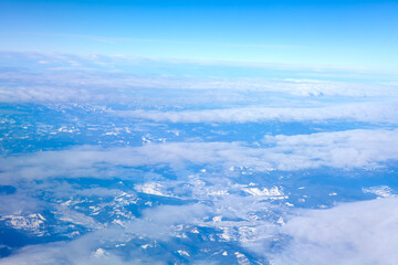 Flight over the Alps. Aerial view of snowy mountains and clouds 