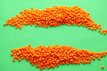 Pile of fresh lentil at green background . Legume studio shot