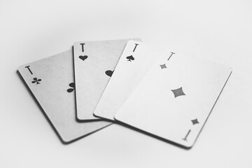 Four aces are fan-shaped on a white table. Four rockets