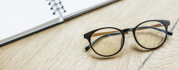 Glasses at the workplace in the office near the notepad. Business hours