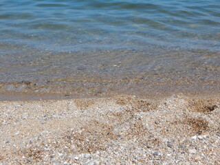 Fototapeta na wymiar edge of the shore, water on the sand, summer time, relax