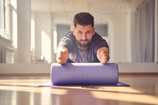 Bearded Young Man Doing Exercise With Yoga Roller Block