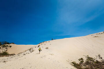 Fototapeta na wymiar Young man on White sand dunes in Vietnam