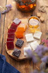 On a wooden board marmalade of different colors, teapot with green tea. Tea ceremony.
