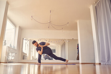Handsome young man doing prayer twist pose