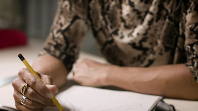 Fashion designer sketching for a creative project. Conceptualizing creative project. Small business back to work. Shot in 4k.