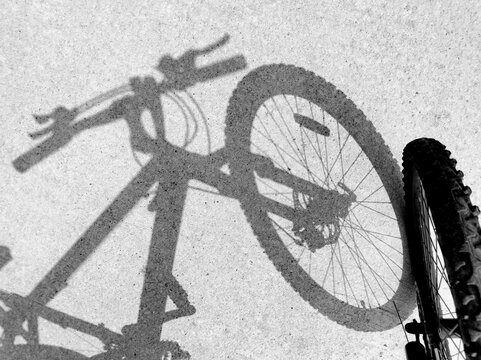 Light and shadow of the bicycle on the road surface.