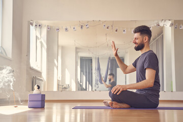 Male yoga instructor using wireless robot camera during yoga session