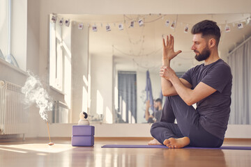 Male yoga practitioner doing half lord of the fishes pose in studio