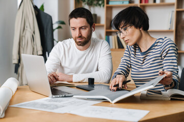 Obraz premium Photo of young colleges discussing project while working in office