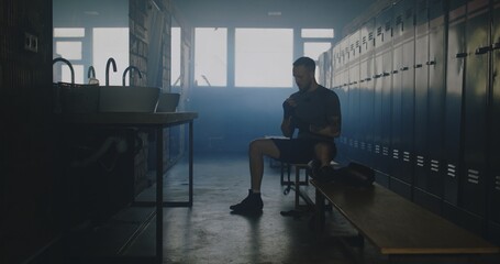 Caucasian male wraps his hands in locker room before boxing martial arts training
