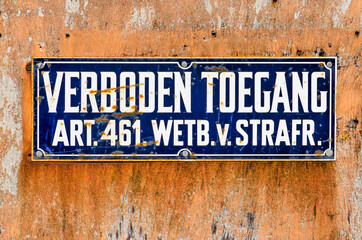 Slightly rusty sign with in Dutch the words "forbidden entry" on a dirty piece of wood
