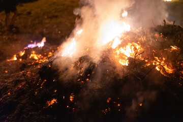 Fototapeta na wymiar Big pile of ashes burning in the night