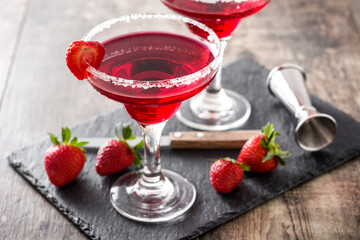 Strawberry margarita cocktail in glass on wooden table