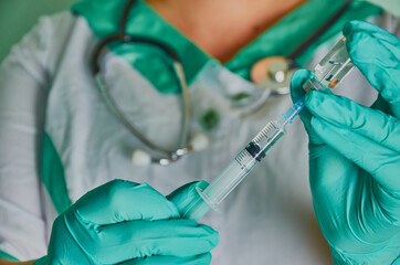 Nurse with syringe in green gloves. Syringe, medical injection, palm or fingers. Medicine plastic vaccination equipment with needle. Nurse or doctor. Liquid drug or narcotic. Health care in hospital.