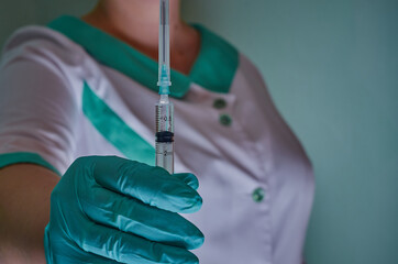 Nurse with syringe in green gloves. Syringe, medical injection, palm or fingers. Medicine plastic...
