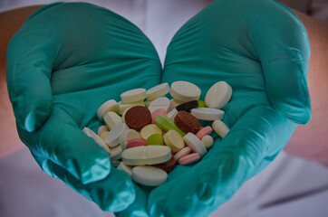 The hands of the medical worker in rubber gloves hold the medicine tablet ampoules and syringes...