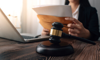 Justice and law concept.Male judge in a courtroom with the gavel, working with, computer and docking keyboard, eyeglasses, on table in morning light