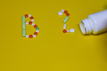 Pills forming shape to B 2 alphabet on yellow background