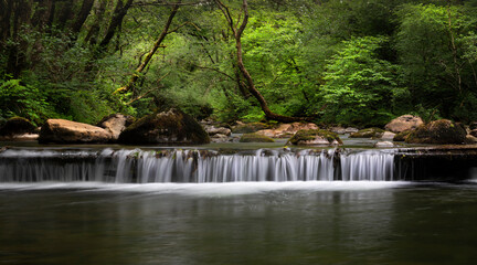 The weir on the Afon Twrch, a river that rises in the Black Mountain in South Wales, seen here at Cwmllynfell in the Twrch valley in South Wales, UK
