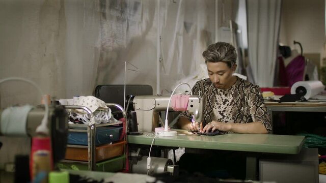 Fashion designer sowing in the studio. Art and creativity in a small business. Authentic real people. Shot in 4k. 