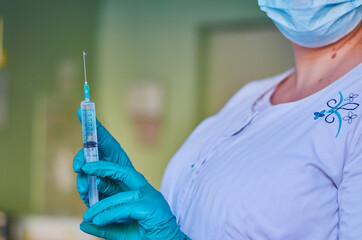 Nurse with syringe in green gloves. Syringe, medical injection, palm or fingers. Medicine plastic...