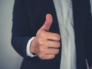 Close up of business man showing thumb up in concept approval or good business.