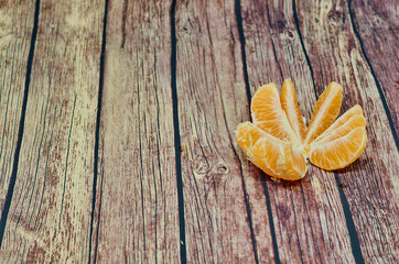 Ripe orange mandarins on the gray wooden background, top view, empty space