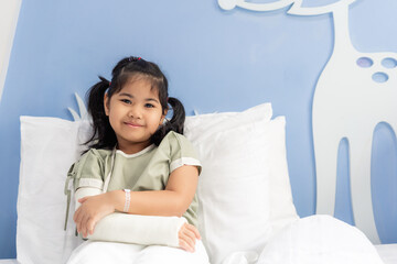 Asian girl treatment in hospital lying on the bed hurting with broken arm back from surgery.