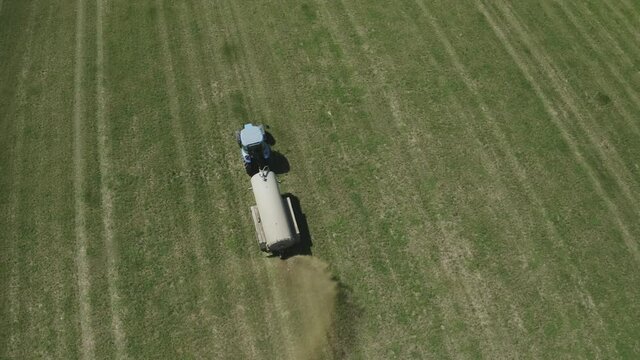 Aerial view of farming tractor. Natural eko fertilizer with manure.  Trailer fertilizes a freshly plowed agriculural.