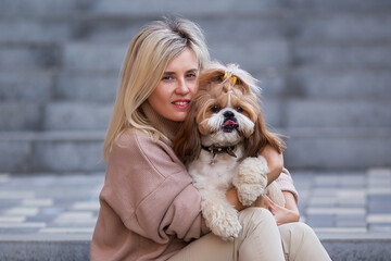 Portrait of a beautiful woman with a cute shih tzu dog.