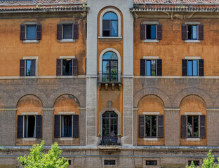 Fototapeta na wymiar vintage apartment building decorated facade with windows pattern on Tiber river, Rome Italy