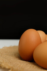 Close up fresh chicken eggs on linen tablecloth and white table with copy space .