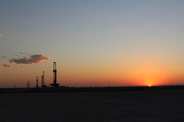 sunset over scenic West Texas landscape with FIVE drilling rigs in the background