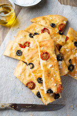 Homemade focaccia with black olives, cherry tomatoes, rosemary and salt