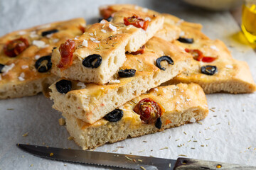 Homemade focaccia with black olives, cherry tomatoes, rosemary and salt