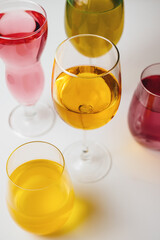 Glasses with multi-colored drinks on a white background.