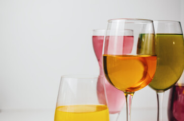 Glasses with multi-colored drinks on a white background.