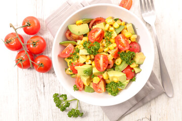 tomato salad with corn, avocado and parsley