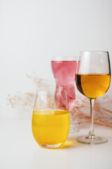 Glasses with multi-colored drinks on a white background.