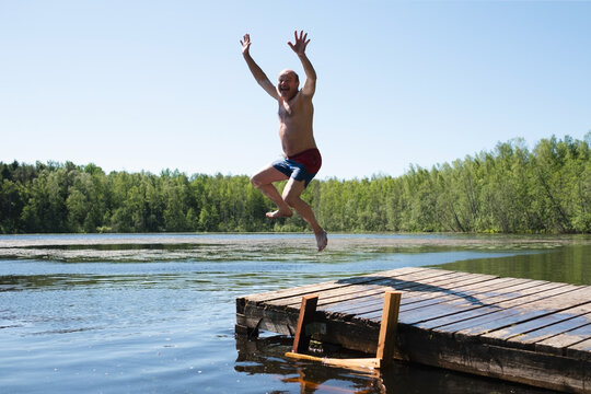 Man Jump To Lake Water Having Fun During Vacation.