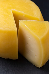 Cheese slice and a hole piece of cheese on a stone 