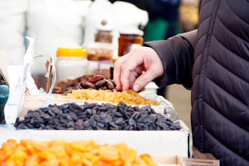 Customer taking yellow sultanas among dry fruits