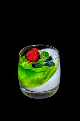 Homemade yogurt with green berry jelly or yogurt in glasses is served with fresh strawberries,...