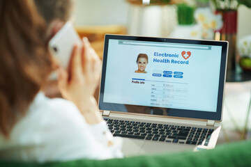 woman at home using cell phone and checking ehr