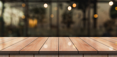 Empty wooden table top with lights bokeh on blur restaurant background