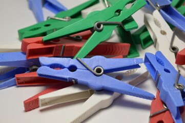 A lot of colored plastic clothespins on a white background